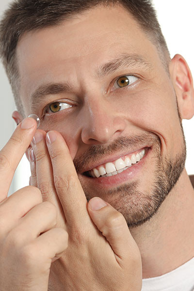 homme essayant de mettre ça lentille de contact 