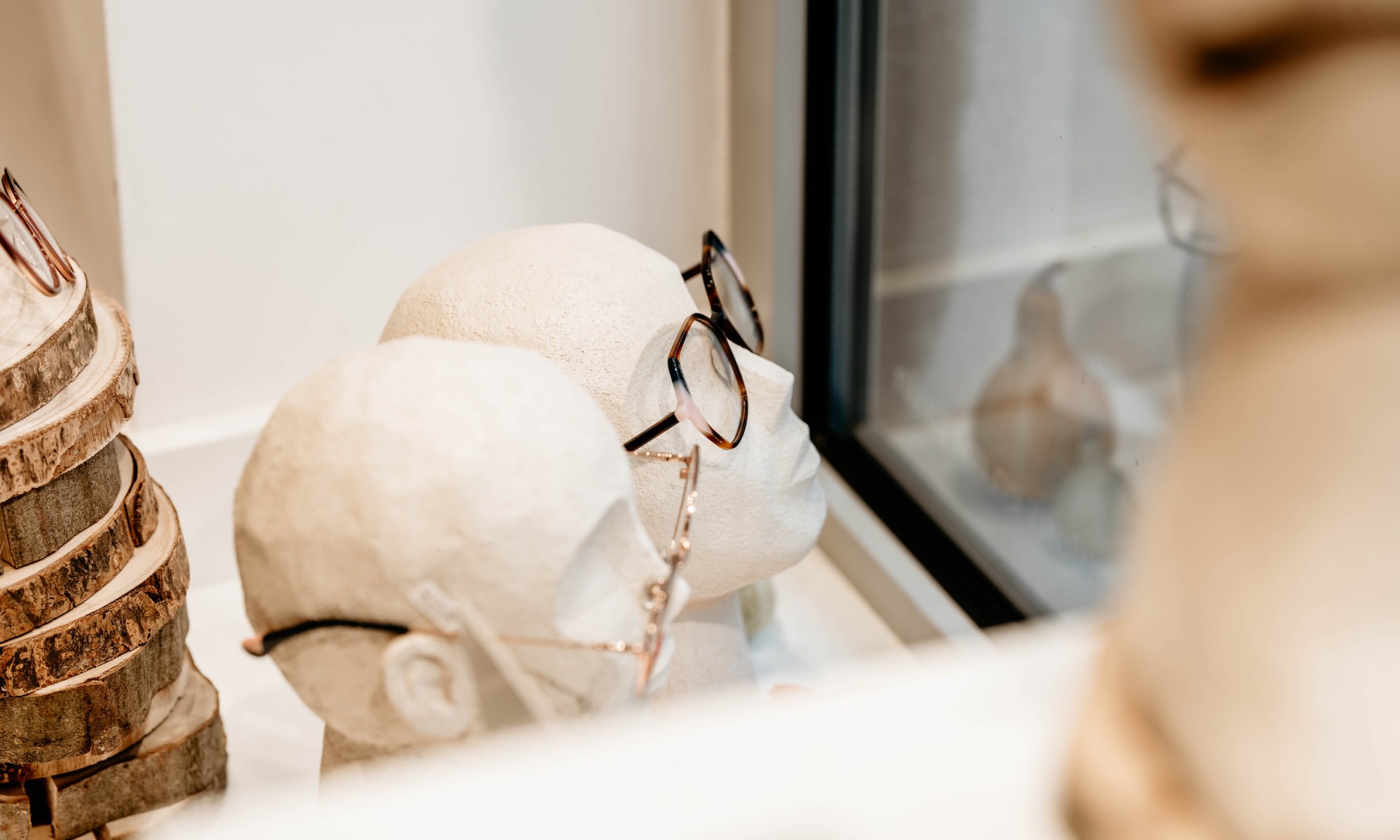 présentoirs avec plein de lunette de tous style exposées 2 tête présentoires avec des lunettes