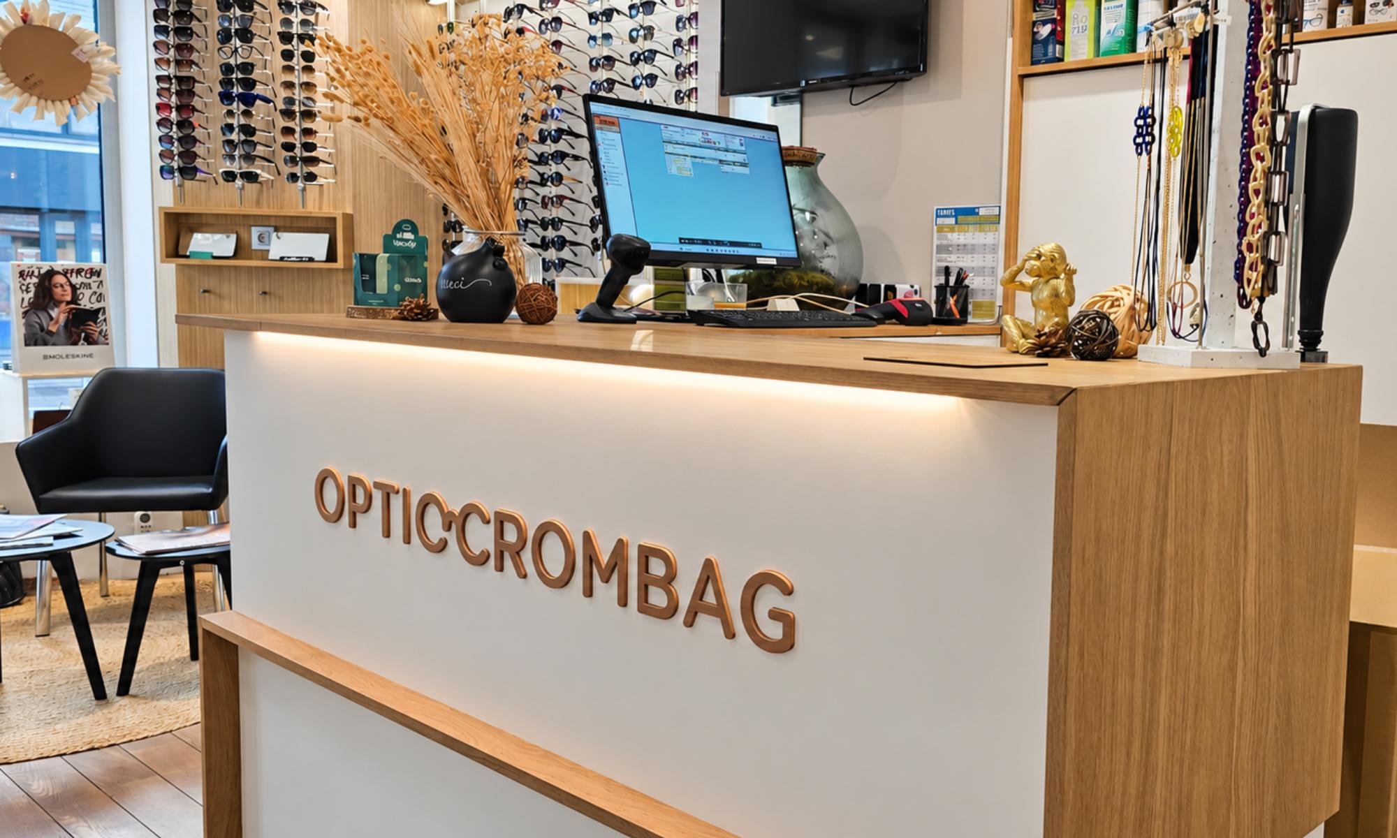 on voit le comptoire d'un magasin d'optique avec le logo de l'entreprise dessu optic crombag 