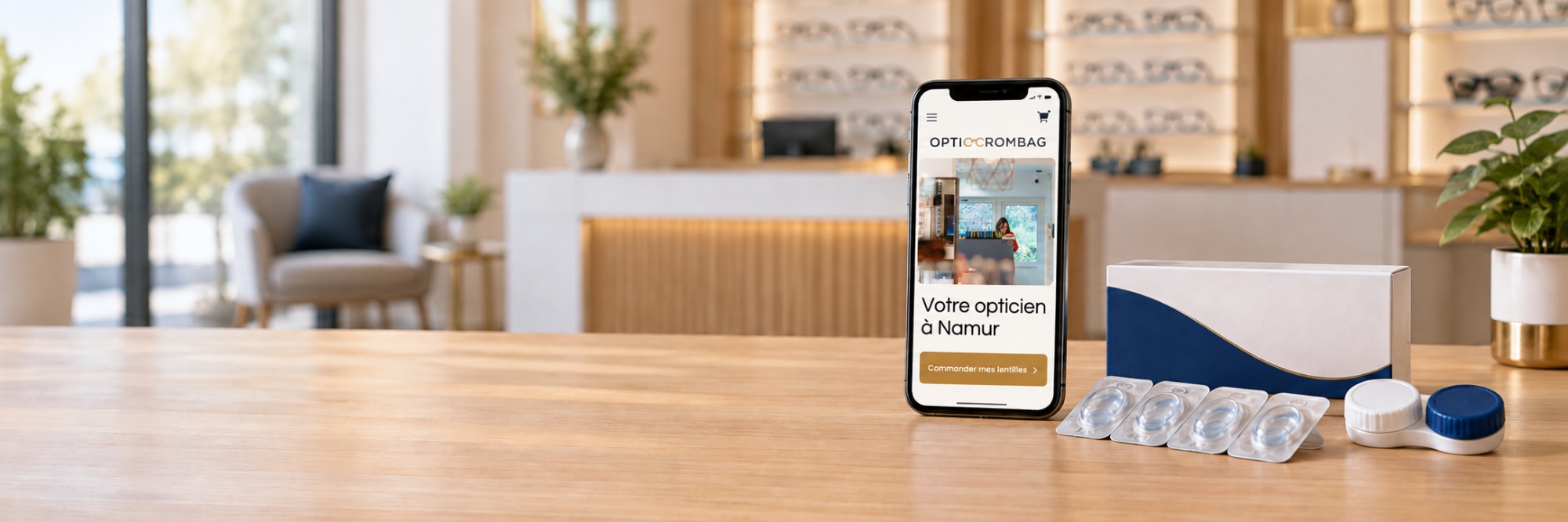 Smartphone affichant une boutique en ligne, à côté de lentilles de contact sous blister et d’un étui sur un comptoir d’opticien.