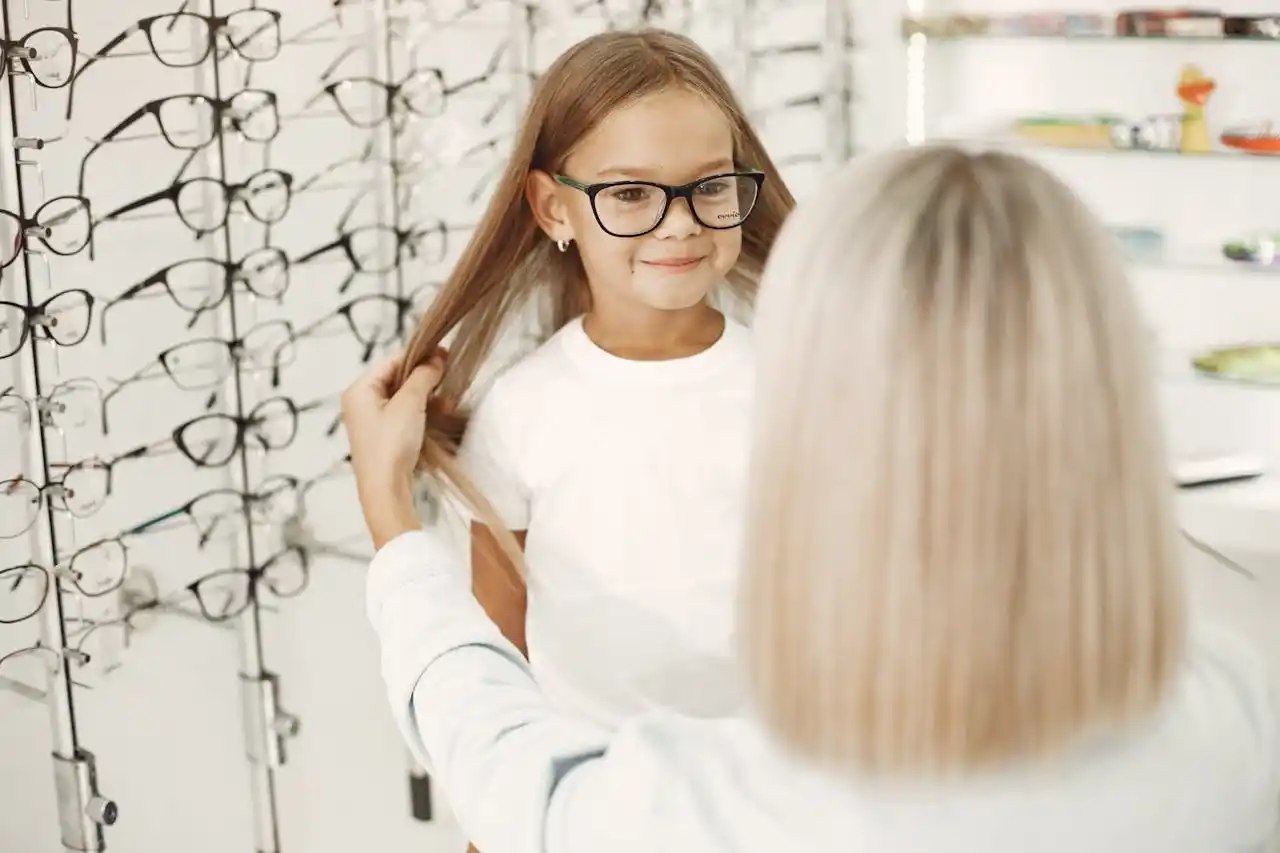 opticienne qui fait tester des lunettes de vue à une enfant